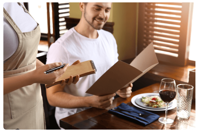 garçom atendendo um cliente em um restaurante