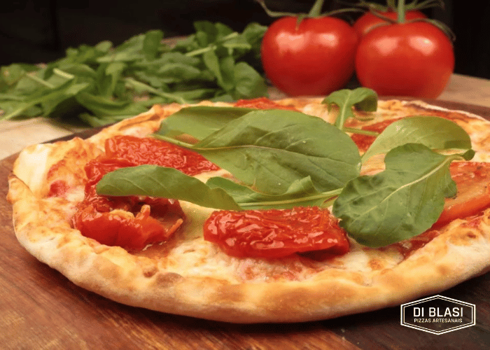 Deliciosa pizza de tomates com rúcula da Di Blasi cliente Saipos