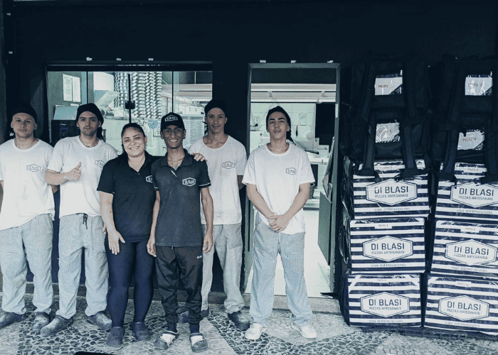 Equipe Di Blasi cliente Saipos posando em frente a fachada da unidade da Ilha do Governador/RJ