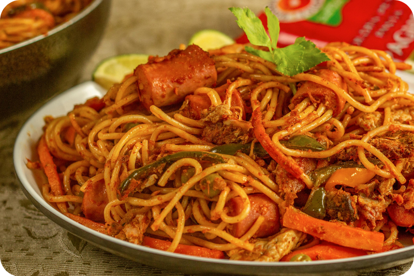 Macarrão espaguete com molho vermelho, legumes e carnes servido com uma folha verde em cima